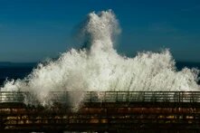 Die nächste Welle: Wie religiöser Extremismus wieder an Macht gewinnt Eine tosende Welle bricht über eine Barriere hinein. Sie schäumt weiss und kommt frontal auf uns zu.