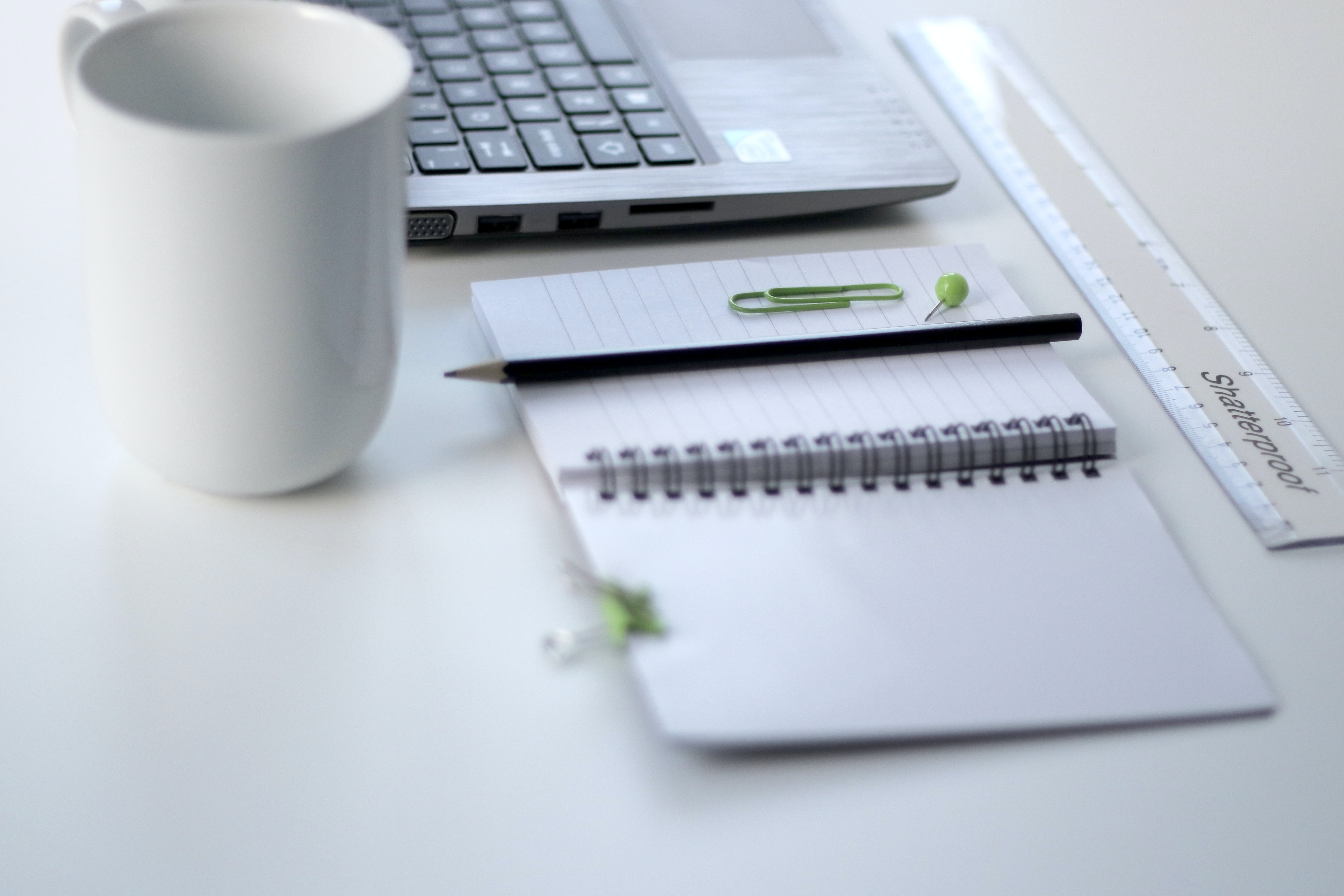 Laptop, Tasse und Notizbuch
