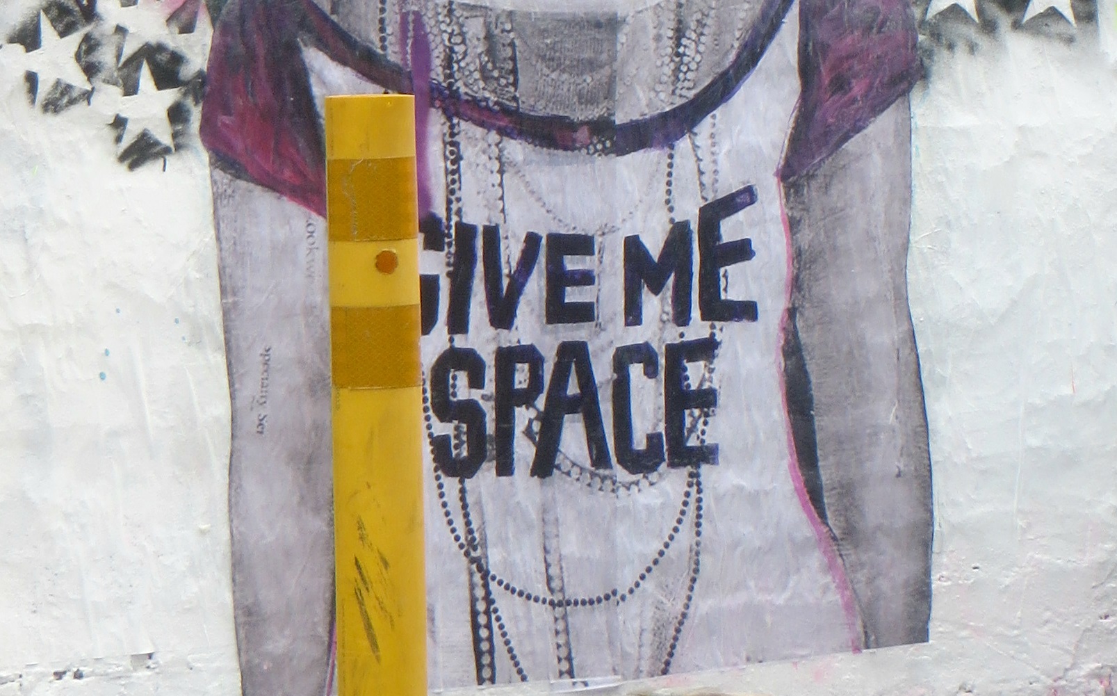 Give me Space Streetart Streetart mit dem Text "Give me space" auf dem weissen T-Shirt einer Person.