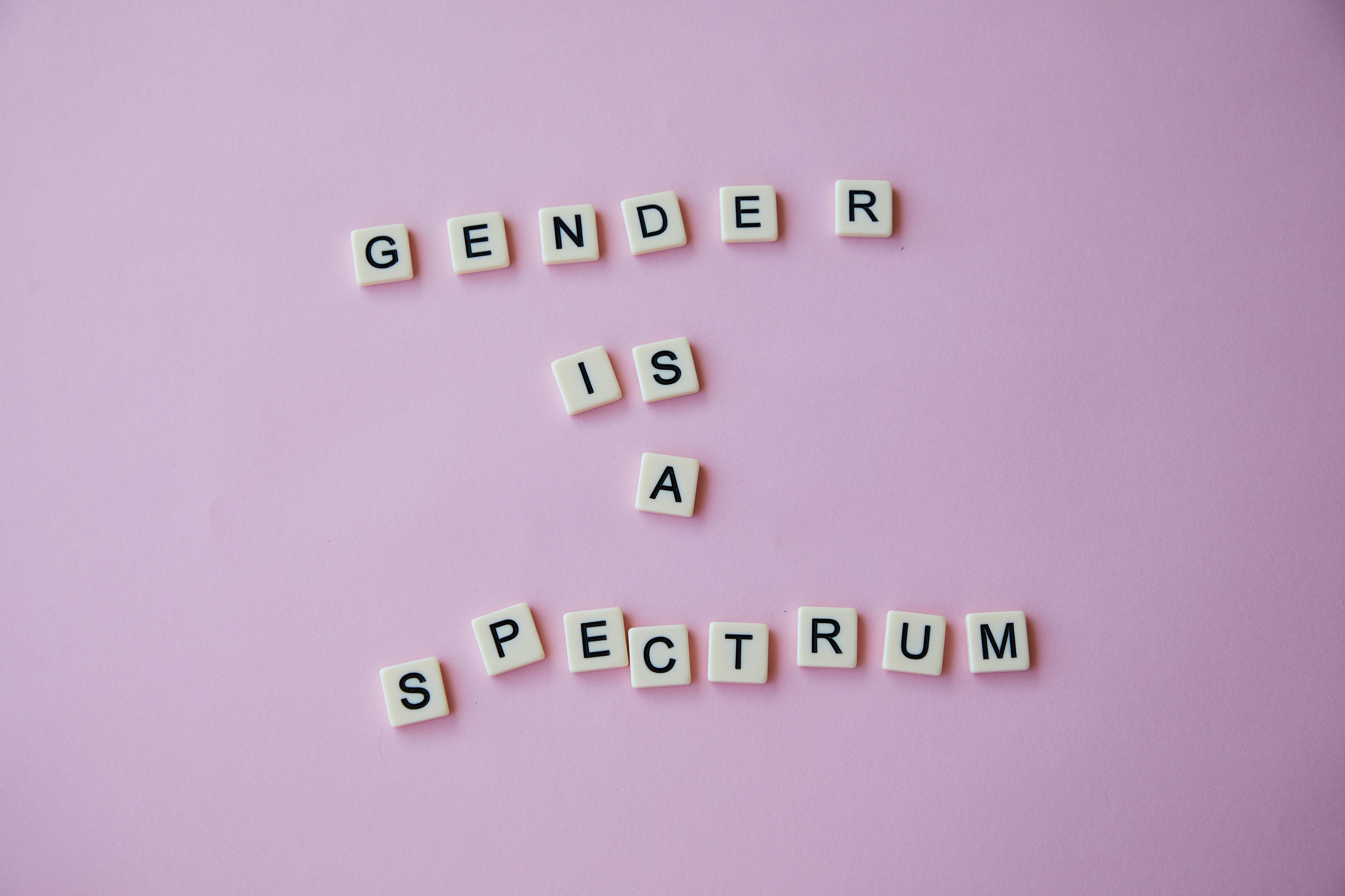Perlen mit Buchstaben, die den Satz "Gender is a spectrum" bilden