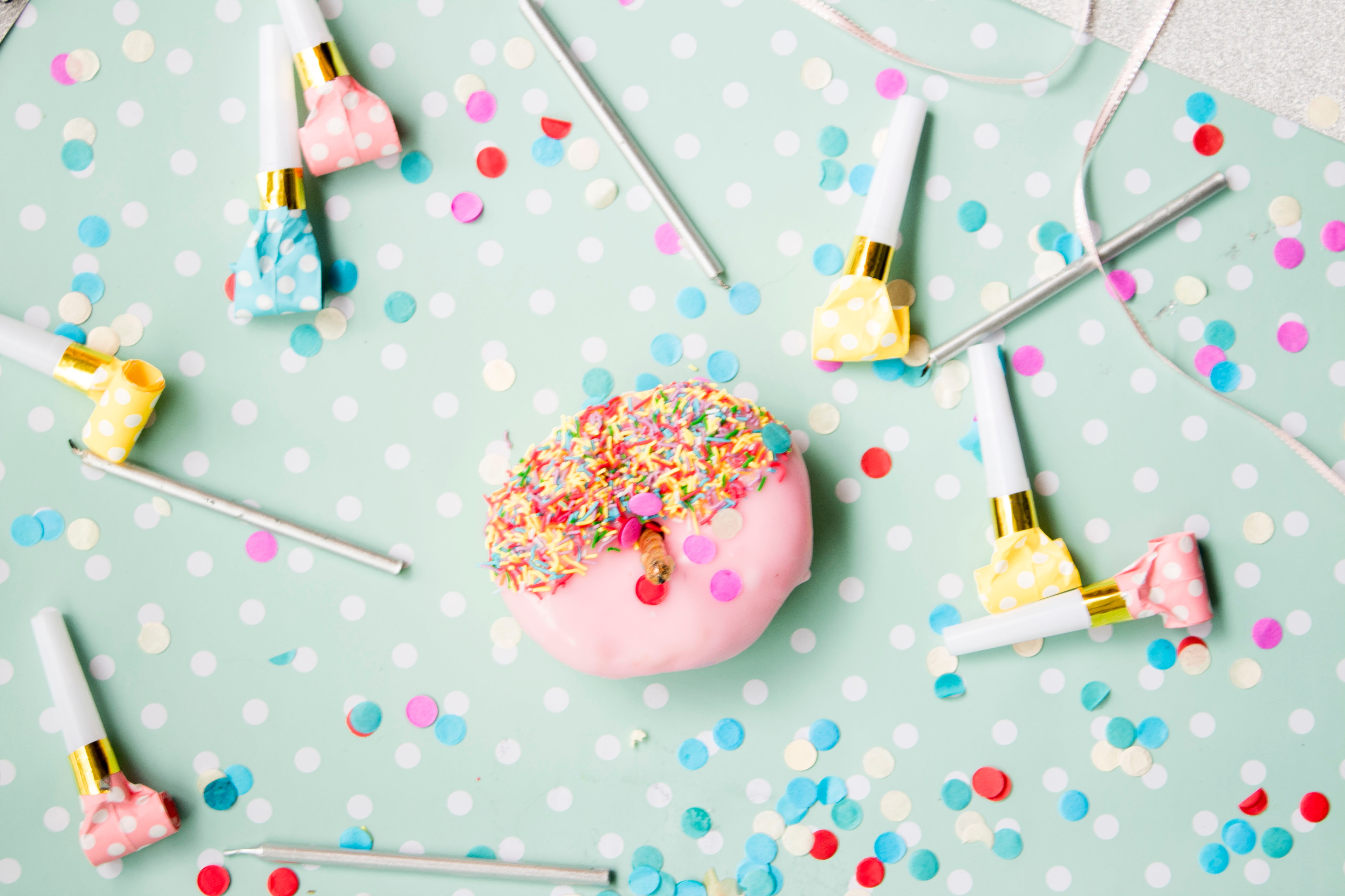 Donut mit Kerze umringt von Partytröten Donut mit Kerze umringt von Partytröten