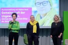 Sabine Hark, Sasha Marinna Salzmann und Ines Kappert vor der Leinwand mit dem Titelbild des neuen Buchs von Sabine Hark