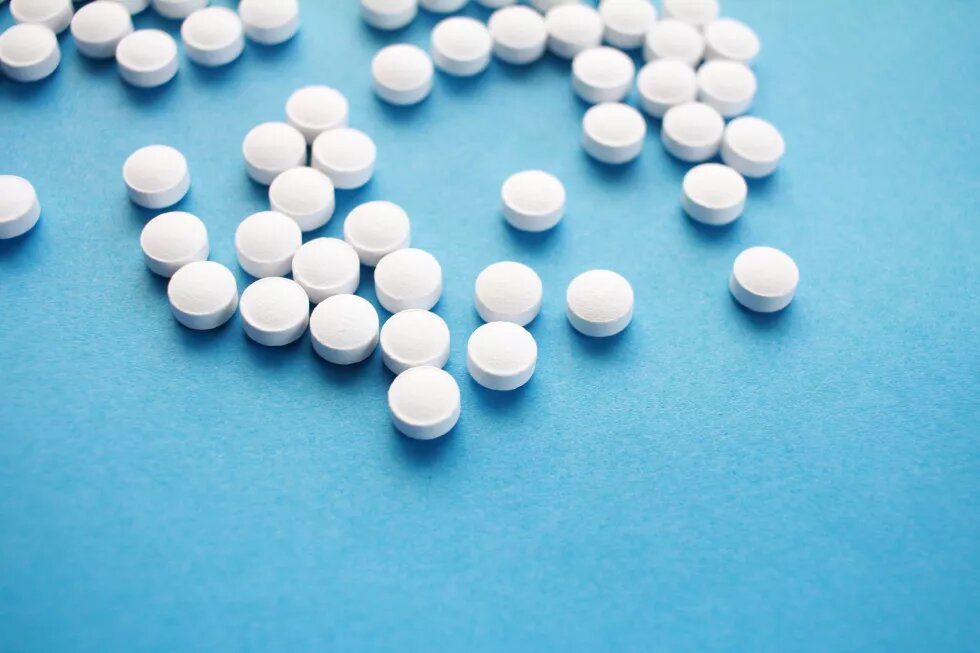 round white pills on blue surface