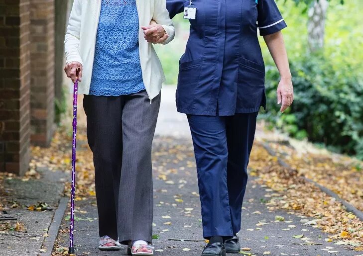 carer taking an older person for a walk