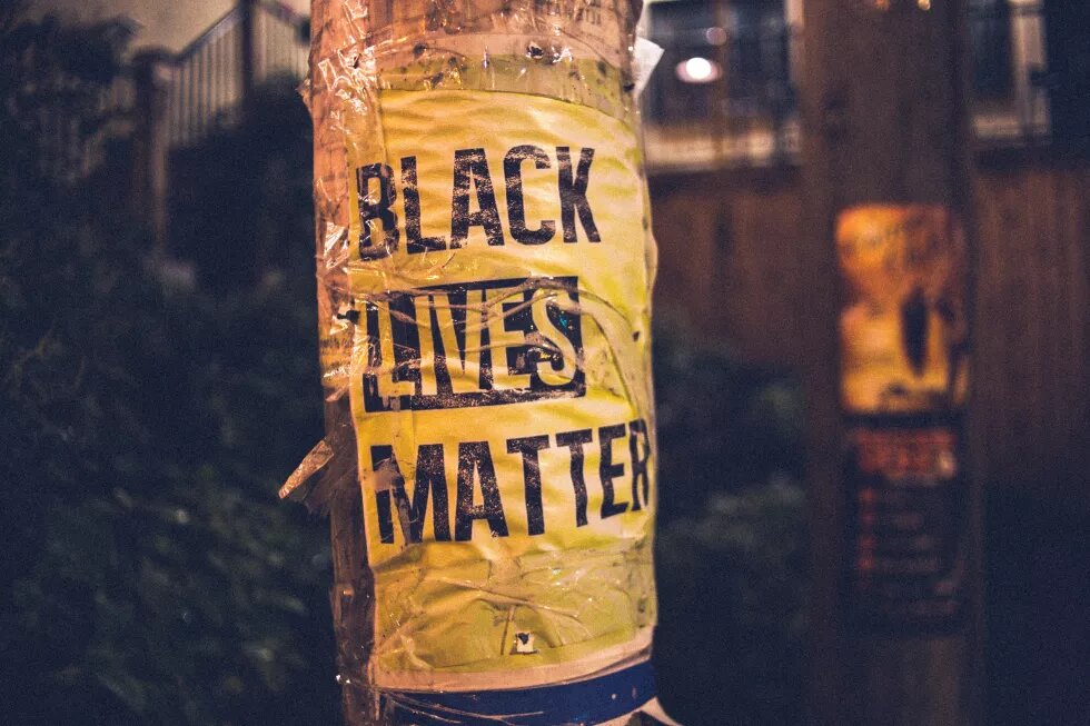 Poster mit Aufschrift "Black Lives Matter" an Straßenmast