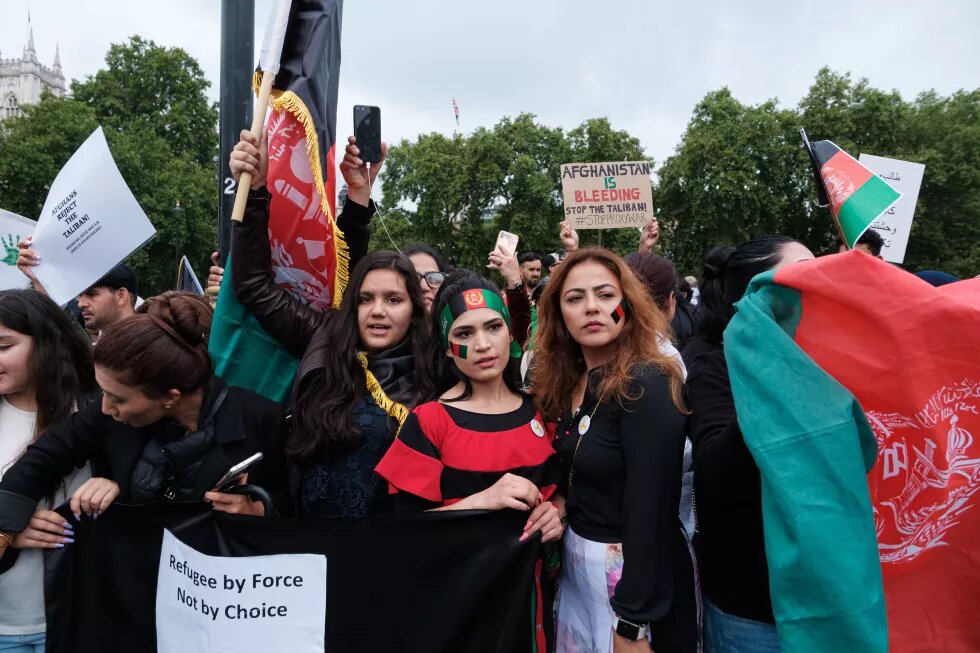 Drei Frauen mit Afghanistan Flaggen in der Hand und im Gesicht auf einem Protest in London. 