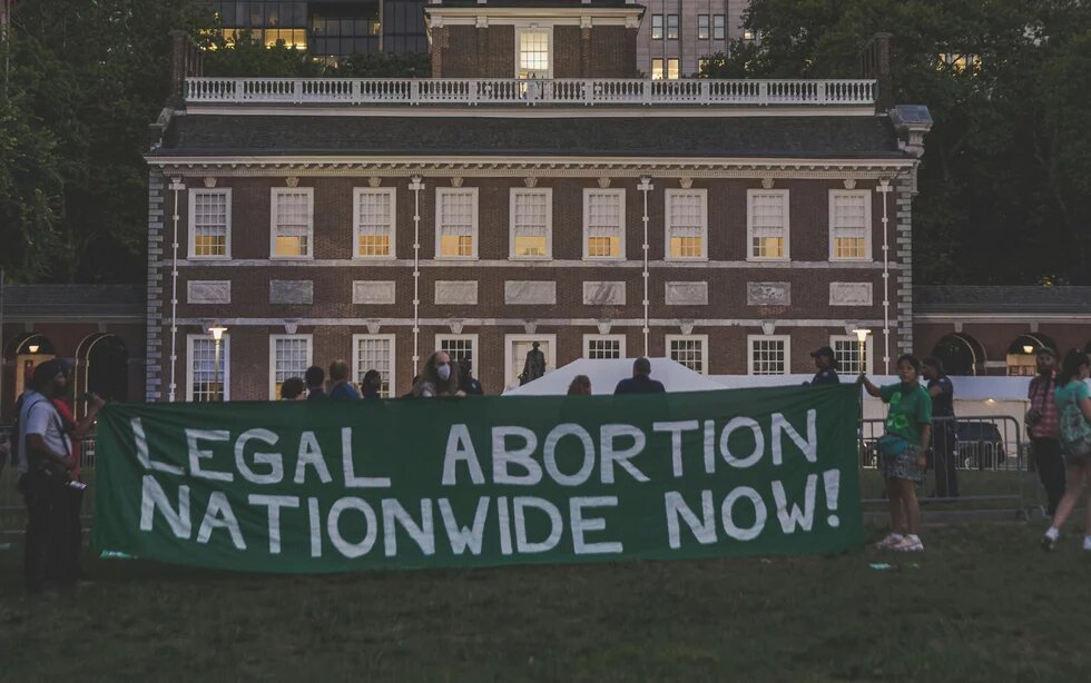 Personen halten ein Transparent mit der englischsprachigen Aufschrift "Legal abortion nationwide now!"