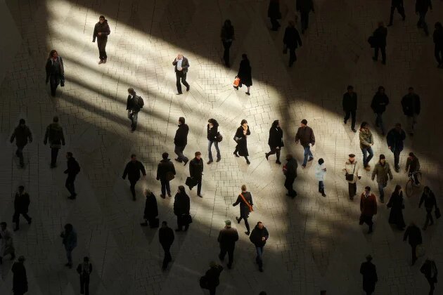 Menschen in Licht und Schatten auf einem Platz