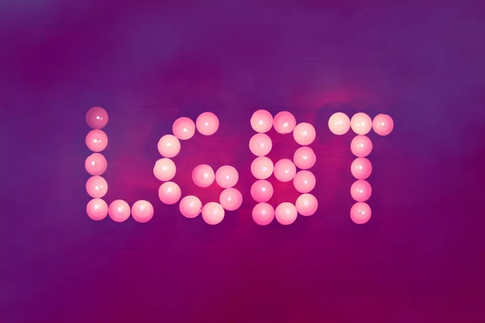 LGBT written with tealights on purple ground