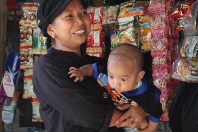 Rusiani and her son Habil in their shop in their shop in rural Indonesia (2010). Access to low-interest loans for small businesses is difficult, particularly for women Indonesian woman with baby